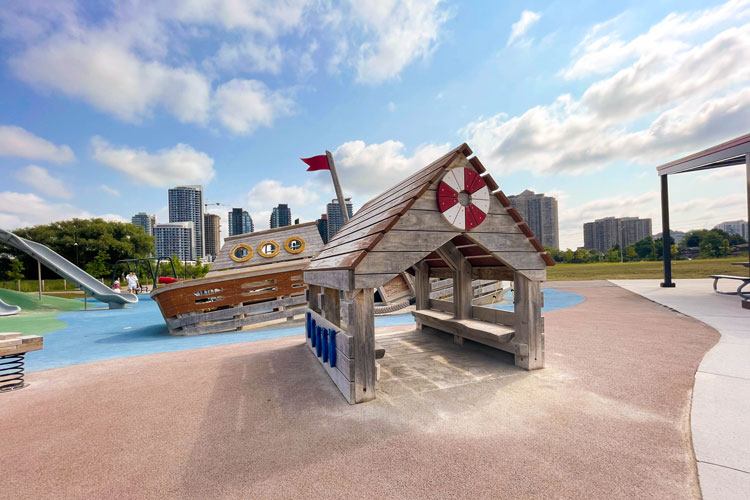 Wooden house and ship at the pirate-themed playground at Fairwinds Park