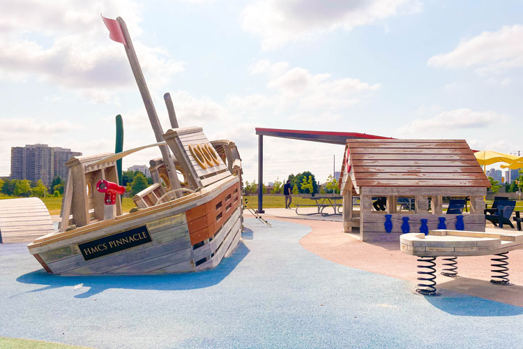 Wooden house and ship at the pirate-themed playground at Fairwinds Park