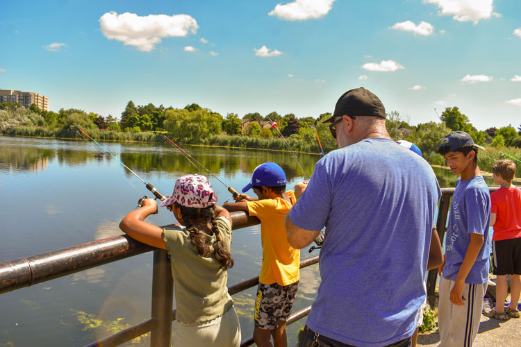 Families fishing at Lake Aquitaine on Family Fishing Day