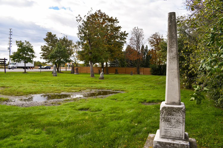 Headstone and water on the lawn of Derry West Cemetery