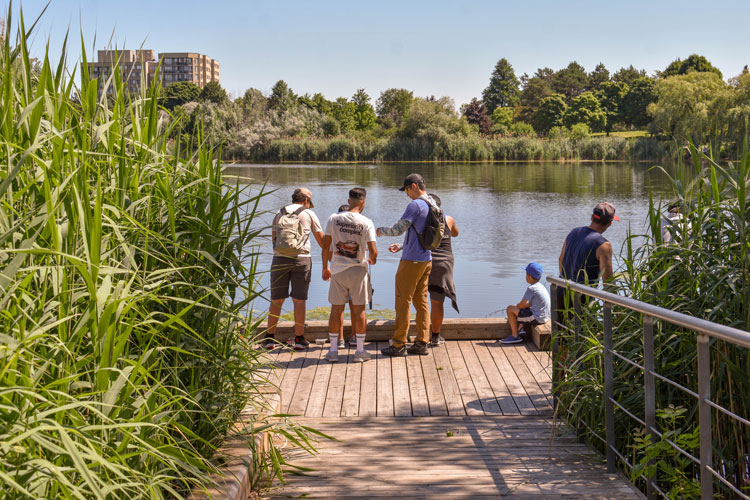 Families fishing off the dock at Lake Aquitaine on Family Fishing Day