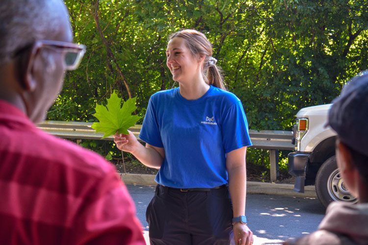 Smiling forestry employee showing off a leaf at Sawmill Valley Trail
